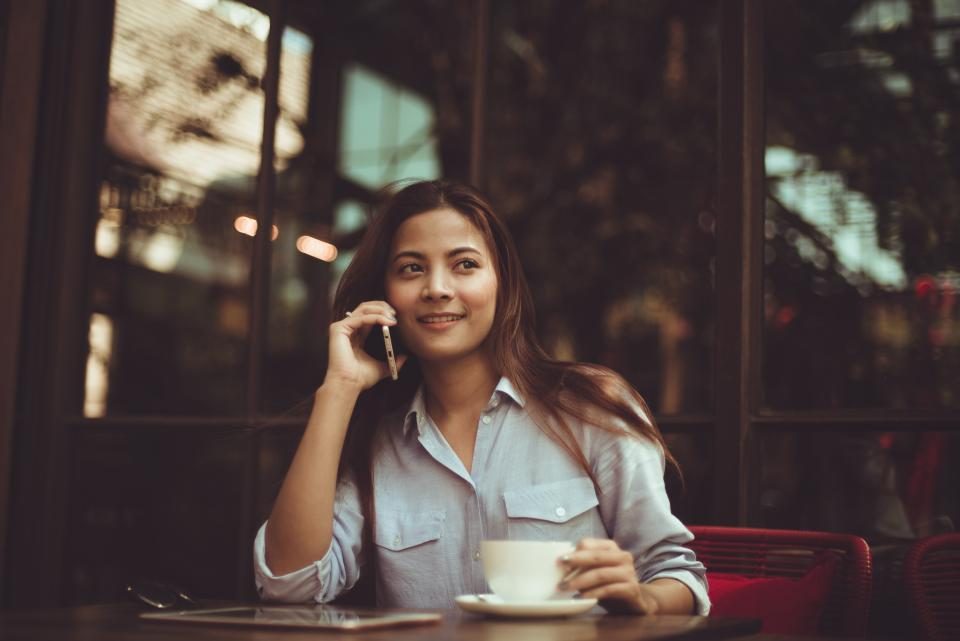 Telefonla müşterisiyle görüşen işletme sahibi